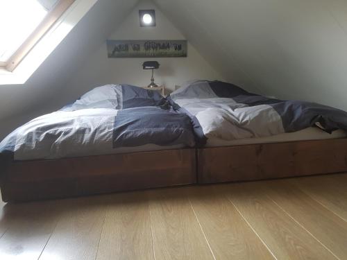 een bed in een kamer met een zolder bij B&B Het Bakhuis in Loenen