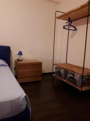 a bedroom with a bed and a dresser with a lamp at Appartamento Via Gentile in Foggia