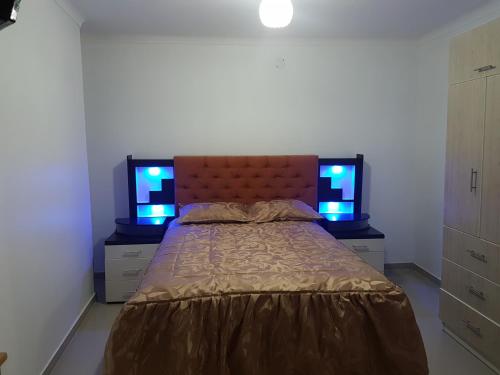 Un dormitorio con una cama con dos monitores. en Nino´s Residence Departamentos VIP Amoblados en Tacna