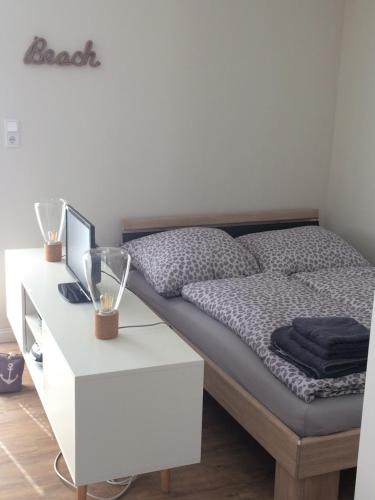 Schlafzimmer mit einem Bett und einem weißen Schreibtisch in der Unterkunft „Lüttje Nüst“ in Emden