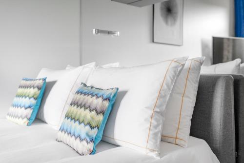 a white couch with four pillows on it at The Joseph in Vilnius