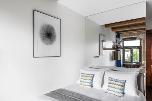 a bedroom with a white bed with blue and white pillows at The Joseph in Vilnius