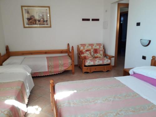 MontescudoにあるB&B Castellanoのベッドルーム1室(ベッド2台、椅子、ソファ付)