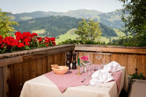 a table with a plate of food and wine glasses at Gasthof Kronreith in Maria Alm am Steinernen Meer