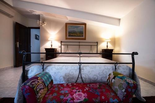 a bedroom with a bed with two chairs and two lamps at B&B Da Marcella in Oristano