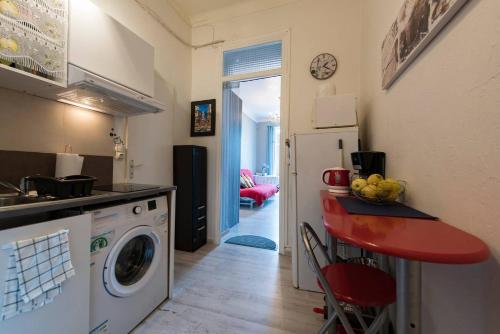 a kitchen with a washing machine and a counter with a table at RIVIERA STUDIO CANNES CENTER in Cannes