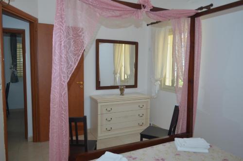 a bedroom with a dresser and a mirror at Ansise apartments in Noto Marina