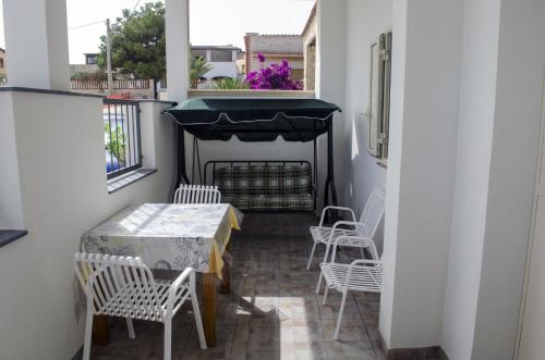 a balcony with a table and chairs and a window at Ansise apartments in Noto Marina