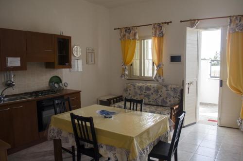 a kitchen and dining room with a table and chairs at Ansise apartments in Noto Marina
