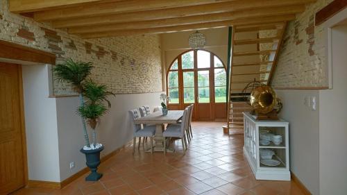 une salle à manger avec une table et des chaises et une fenêtre dans l'établissement Le Clos du Cèdre, à Launac