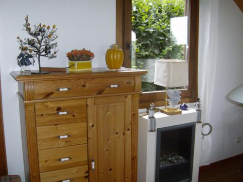 WibrinにあるLa Maison en Boisの木製ドレッサーと窓が備わる客室です。