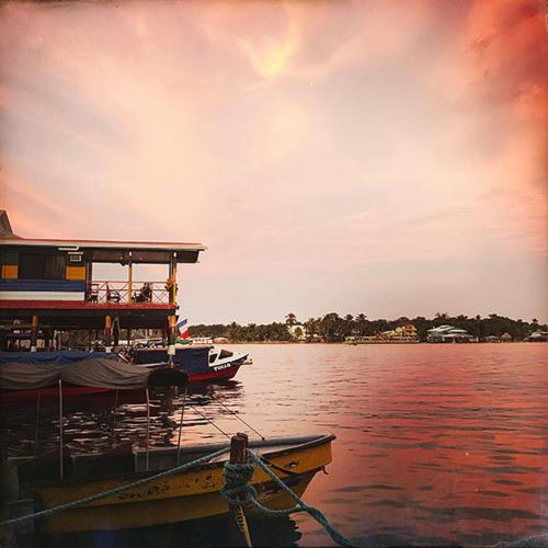 two boats are docked on the water at a dock at Hotel Bocas del Toro in Bocas del Toro