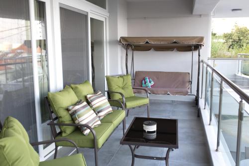 a balcony with chairs and a bed and a table at Blue4Aqua Apartments in Kavala