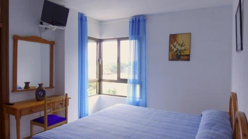 1 dormitorio con cama y ventana en Hotel Candano, en Isla