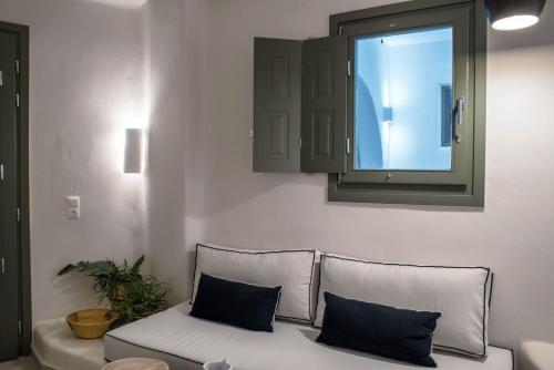 a couch with two pillows sitting in a living room at Melidron Hotel & Suites in Agios Prokopios