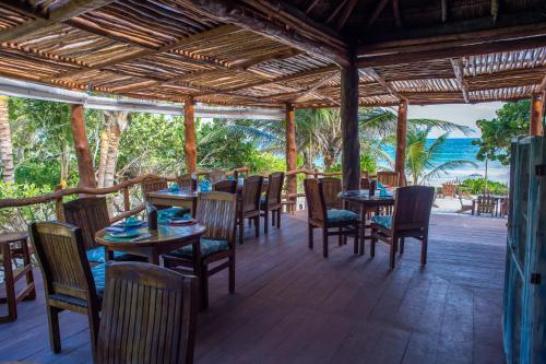 
a patio area with tables, chairs and umbrellas at Cabañas La Luna in Tulum
