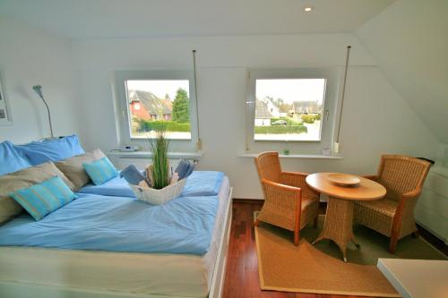 - un salon avec un canapé, une table et 2 fenêtres dans l'établissement Ferienwohnungen Wyk/Föhr, à Wyk auf Föhr