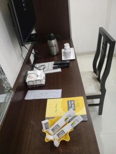 a wooden desk with a computer monitor and a keyboard at Hotel One Up in Ahmedabad