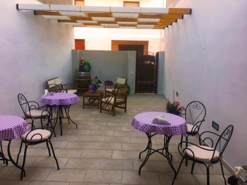a patio with purple tables and chairs and a door at B&B Mariposa in Sennori