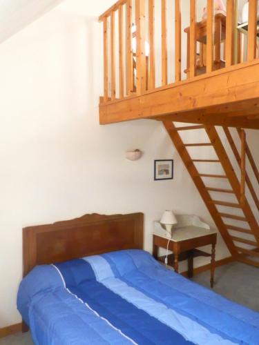 1 dormitorio con 1 cama y escalera de madera en gite des ferrieres, en La Ville-ès-Nonais