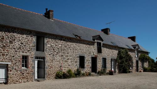 a large brick building with a black roof at gite des ferrieres in La Ville-ès-Nonais