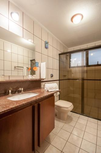 a bathroom with a toilet and a sink and a shower at Saint Peter Hotel in Sao Jose do Rio Preto