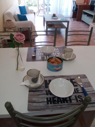 a table with two plates and cups and a table with at CHRYSTALL'S COTTAGE in Lagonissi