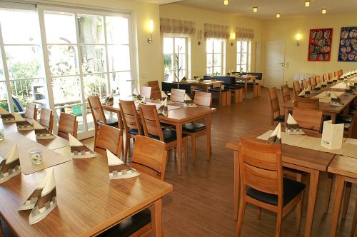 um restaurante com mesas e cadeiras de madeira e janelas em Fränkischer Gasthof Lutz em Giebelstadt