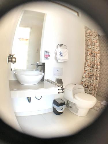 a bathroom with a white toilet and a sink at Casa Villamor in Máncora