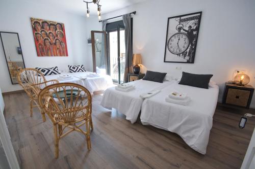 a bedroom with two beds and a clock on the wall at Pension Casa Pinilla in Cascante