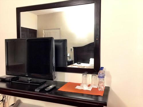 a desk with a television and a mirror at Hotel Alicia Beach in Sosúa