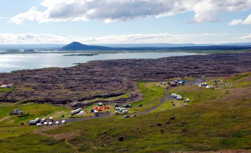 a group of tents on a hill near a body of water at Hlid Cottages in Myvatn