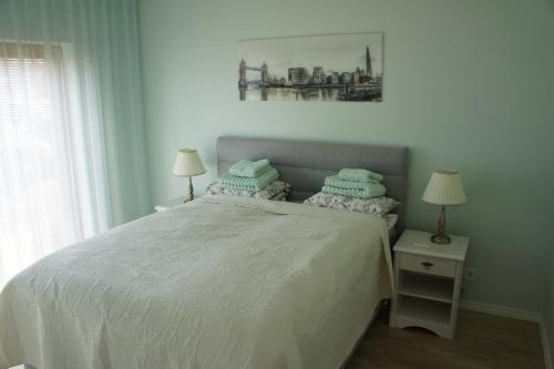 a bedroom with a white bed with two pillows at Kotkapoja Apartment in Kuressaare