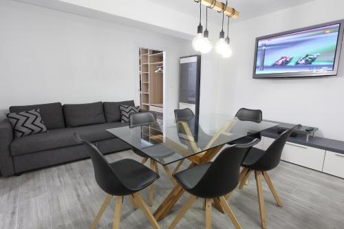 een woonkamer met een glazen tafel en zwarte stoelen bij 5 SENSES in Valencia