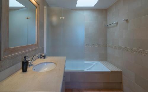 a bathroom with a sink and a bath tub at Can Roig in Santa Gertrudis de Fruitera