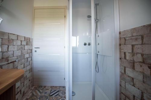 a shower with a glass door in a bathroom at B&B Madonna Carradori Country in Offagna