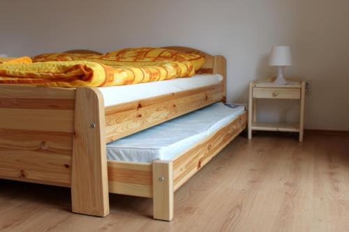 a bedroom with two wooden bunk beds and a table at Penzión Alfréd in Stará Ľubovňa