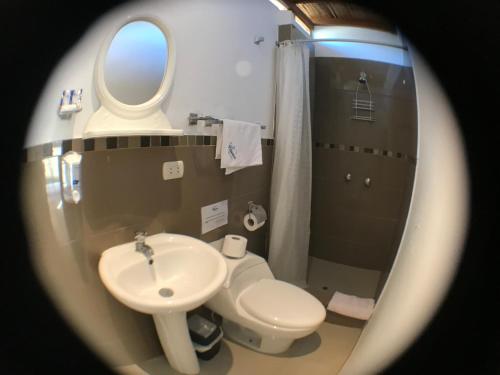 a bathroom with a sink and a toilet and a mirror at Casa Villamor in Máncora