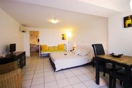 a bedroom with a bed and a table and a desk at Villa Ghiatone in Pietrosella