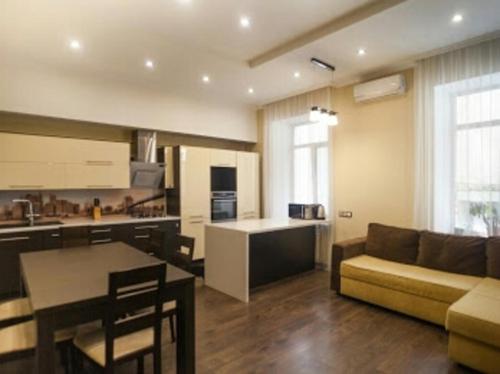 a kitchen and living room with a couch and a table at Апартаменты в центре на Ришельевской in Odesa