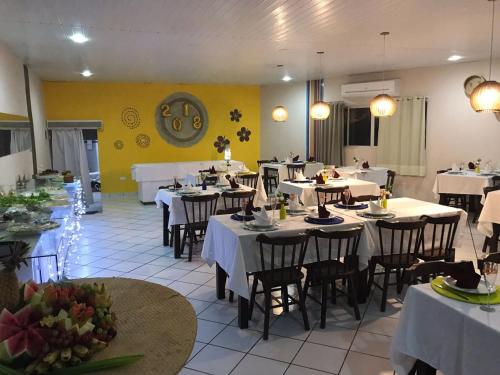 Un restaurante con mesas y sillas con mantel blanco. en Flat Apart Hotel Marinas Tamandaré, en Tamandaré