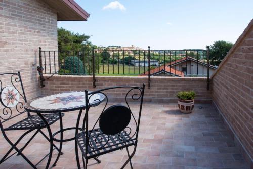 a patio with a table and chairs on a balcony at B&B Madonna Carradori Country in Offagna