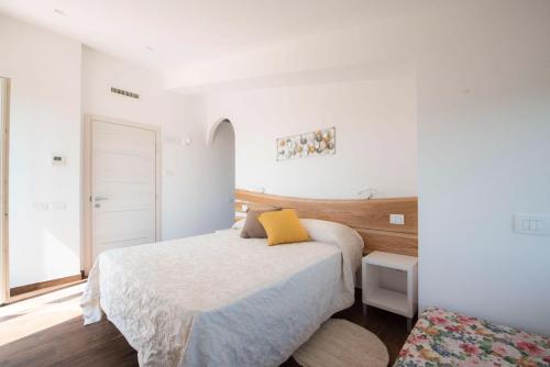 a bedroom with a bed with a yellow pillow on it at B&B Madonna Carradori Country in Offagna