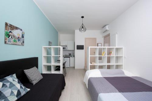 a bedroom with a bed and a couch and a kitchen at Rimini Youth Apartment in Rimini