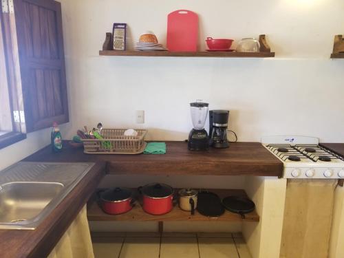a kitchen with a counter with a stove and a sink at Casa Aditi in Mazunte
