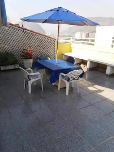 een tafel en twee stoelen en een parasol op een dak bij Penthouse Botafogo Rio de Janeiro in Rio de Janeiro