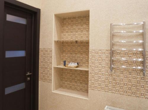 a bathroom with a shower with a shelf on the wall at Апартаменты в центре на Ришельевской in Odesa