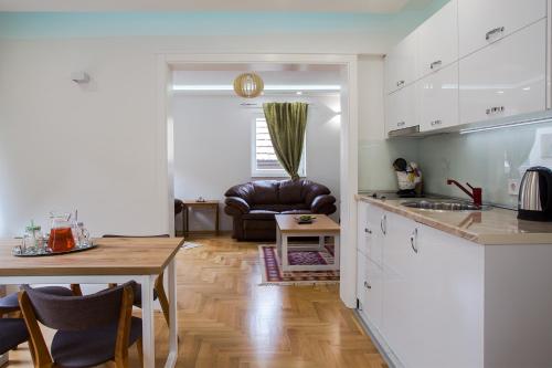 a kitchen and living room with a table and a couch at Guest House Hendek in Sarajevo