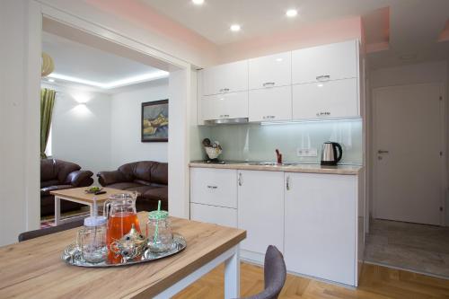 a kitchen with white cabinets and a table with drinks on it at Guest House Hendek in Sarajevo