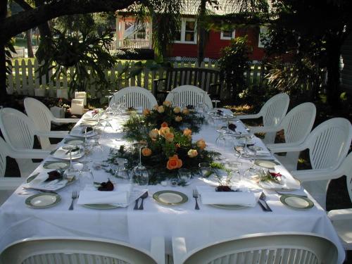 a long table with white chairs and flowers on it at Meranova Guest Inn in Dunedin